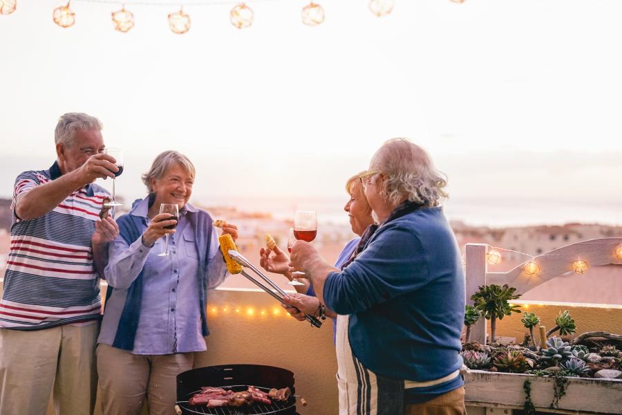 happy senior friends having a barbecue party on a patio